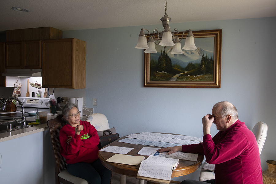 Houngming Christopher, left, talks with her husband, Ronald, while looking over stacks of paperwork and notices of bills unpaid by their tenants. The small landlords, who live in Vancouver, are frustrated about their inability to evict their tenants who aren't paying rent and other bills.