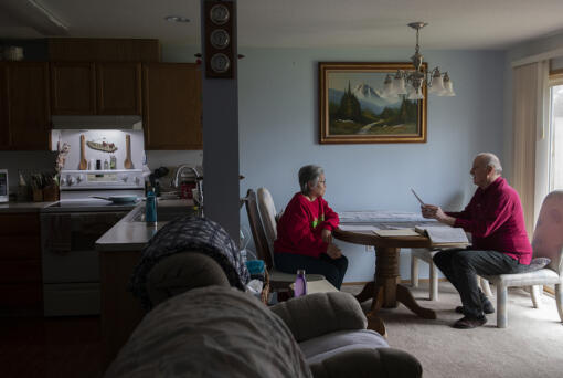 Amanda Cowan/The Columbian
Houngming Christopher, left, and her husband, Ronald, look over unpaid bills for their rental property, half of a duplex occupied by a family of five. The Christophers are owed thousands of dollars in rent and don't know where to turn. (Amanda Cowan/The Columbian)