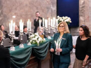 Reps. Sharon Wylie and Monica Stonier prepare to light a candle in memory of the late Rep. Jim Moeller during a joint memorial session at the Capitol on Wednesday.
