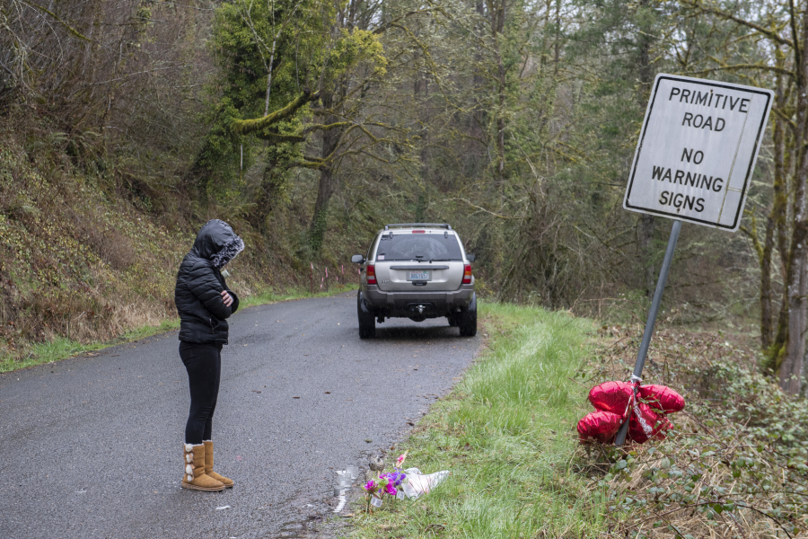 Brandy Pickard of Washougal pauses to honor the memory of Meshay "Karmen" Melendez, 27, and her daughter, Layla Stewart, 7, along Wooding Road on Thursday afternoon. Authorities found two bodies believed to be theirs in a brushy area farther down Wooding Road. "I just feel so bad for their family," she said.