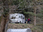 Law enforcement officials work at the scene along Wooding Road east of Washougal on Wednesday afternoon, March 22, 2023. Authorities found two bodies believed to be those of a missing Vancouver woman and her 7-year-old daughter in a brushy area farther down Wooding Road.