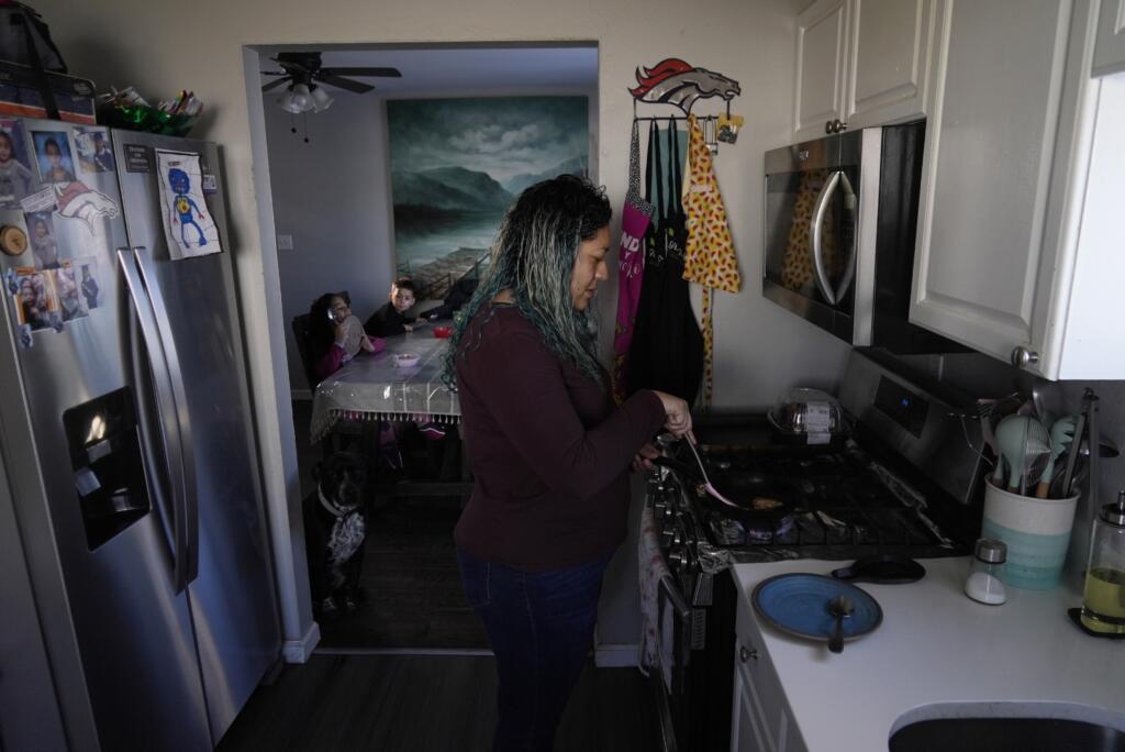 Betty Rivas prepares breakfast for her family Thursday, Feb. 23, 2023, in Commerce City, Colo. Rivas was startled by a letter telling her that the drinking fountains her 8-year-old used at school weren't safe. PFAS stories had been in the local news and the school district told families to use bottled water.