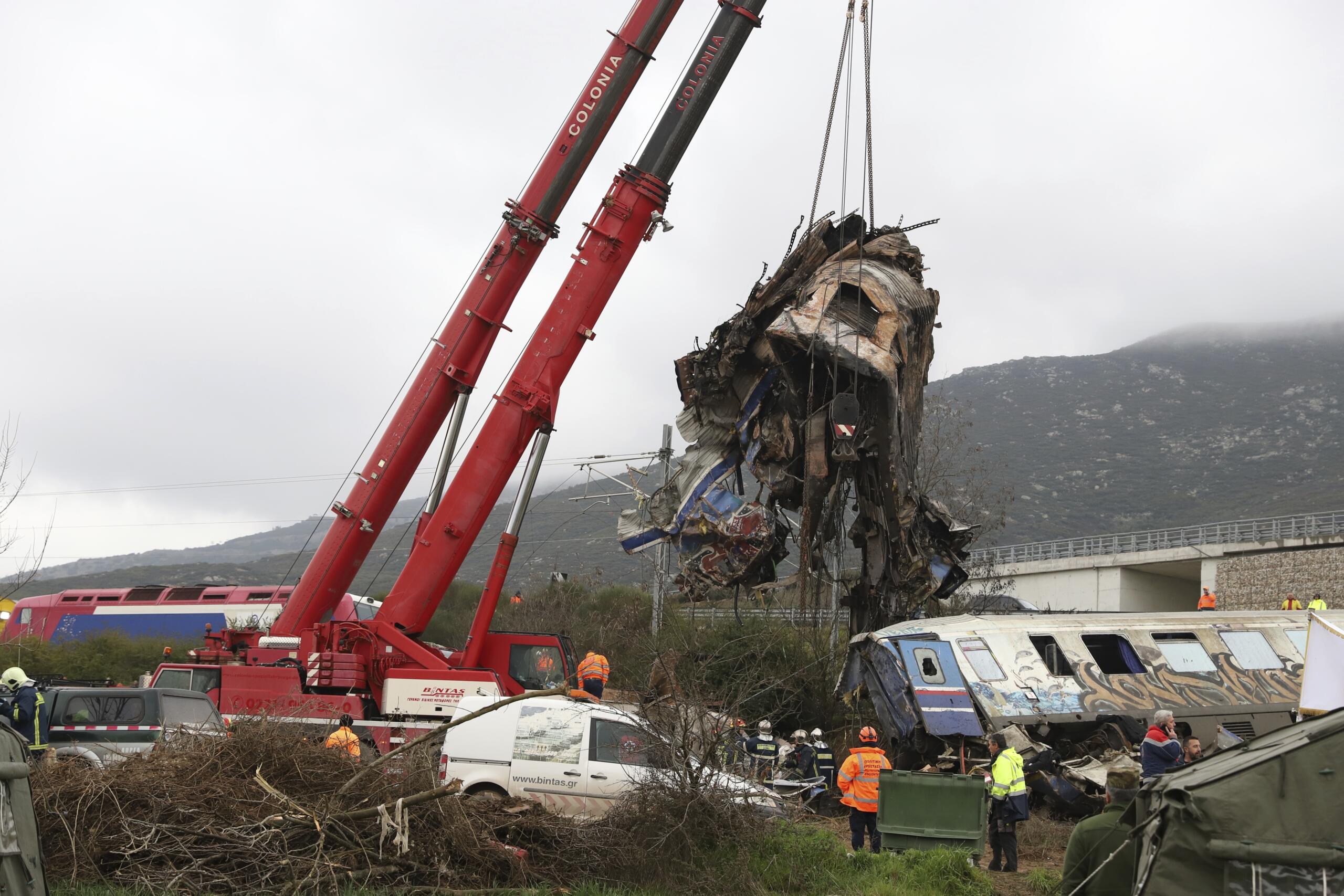 Cranes remove debris after a trains' collision in Tempe, about 376 kilometres (235 miles) north of Athens, near Larissa city, Greece, Thursday, March 2, 2023. Rescuers using cranes and heavy machinery on Thursday searched the wreckage of trains involved in a deadly collision that sent Greece into national mourning and prompted strikes and protests over rail safety.