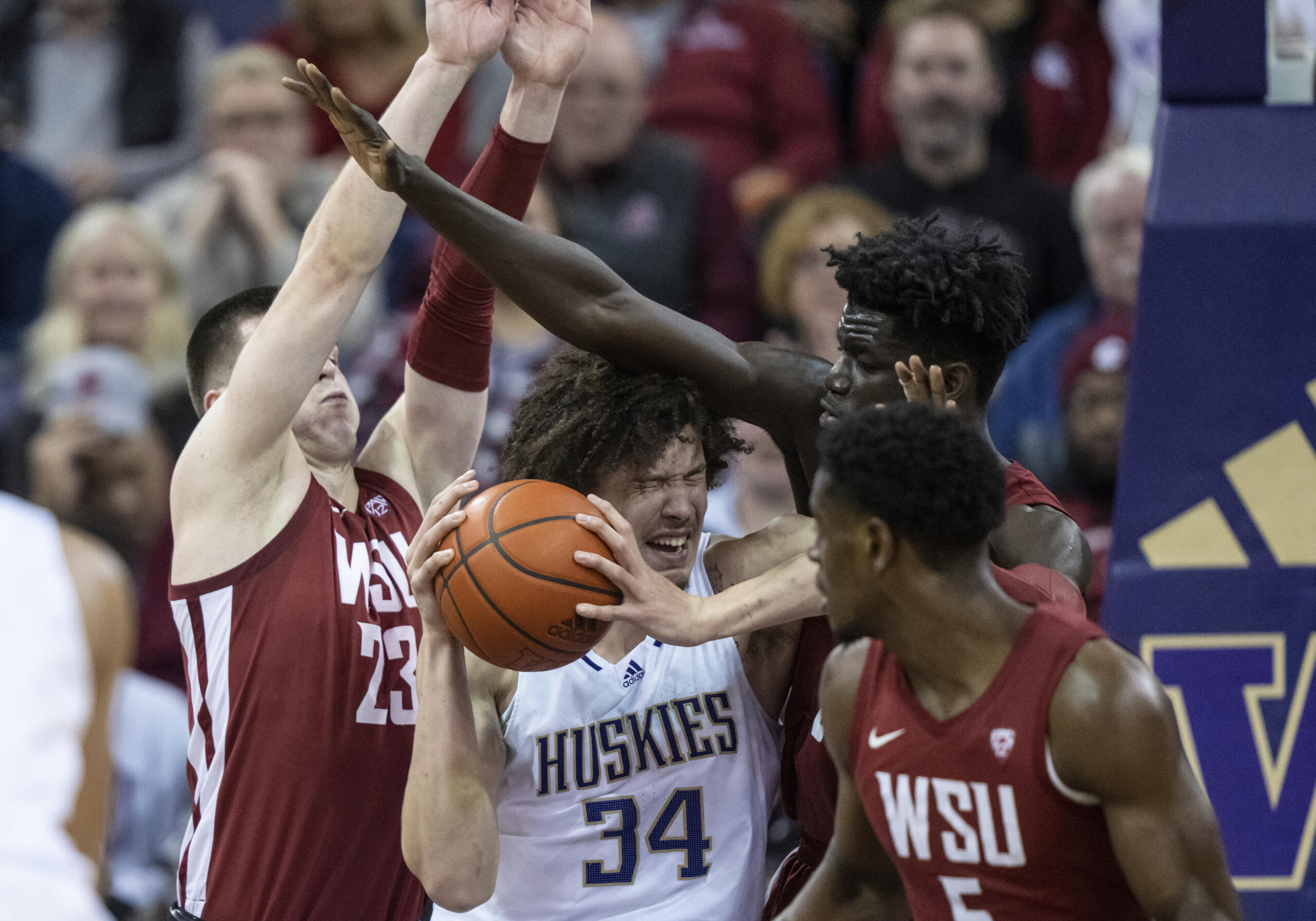 Washington center Braxton Meah, center, attempts to drive against Washington State forward Andrej Jakimovski, left, guard TJ Bamba, right, and forward Mouhamed Gueye during the second half of an NCAA college basketball game Thursday, March 2, 2023, in Seattle.