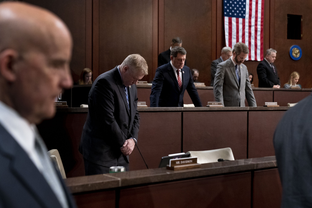 Congressmen stand for a moment of silence for the service members who were killed during the United States evacuation from Afghanistan during a House Committee on Foreign Affairs hearing on Capitol Hill in Washington, Wednesday, March 8, 2023.