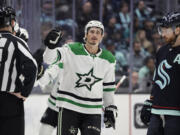 Dallas Stars left wing Mason Marchment, center, celebrates after his goal as Seattle Kraken defenseman Adam Larsson (6) looks on during the second period of an NHL hockey game, Saturday, March 11, 2023, in Seattle.