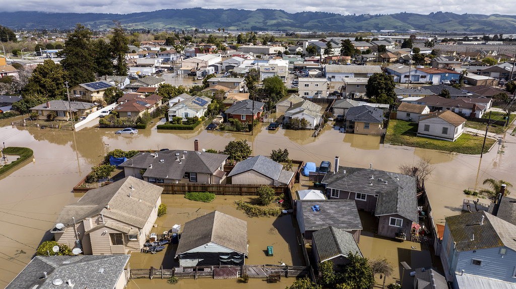 Floodwaters surround homes and vehicles in the community of Pajaro in Monterey County, Calif., on Monday, March 13, 2023.