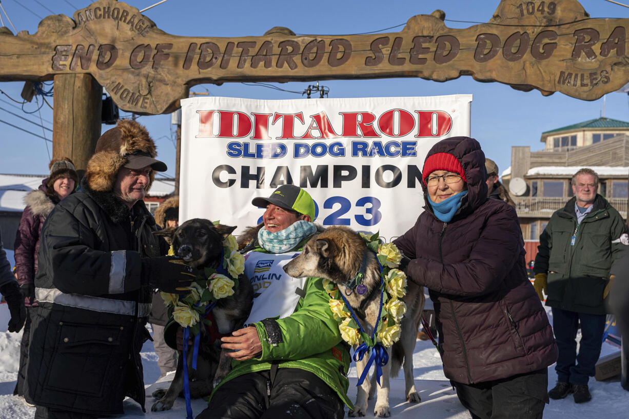 Ryan Redington poses with his lead dogs Sven, left, and Ghost, after he won the 2023 Iditarod Trail Sled Dog Race Tuesday, March 14, 2023 in Nome, Alaska.