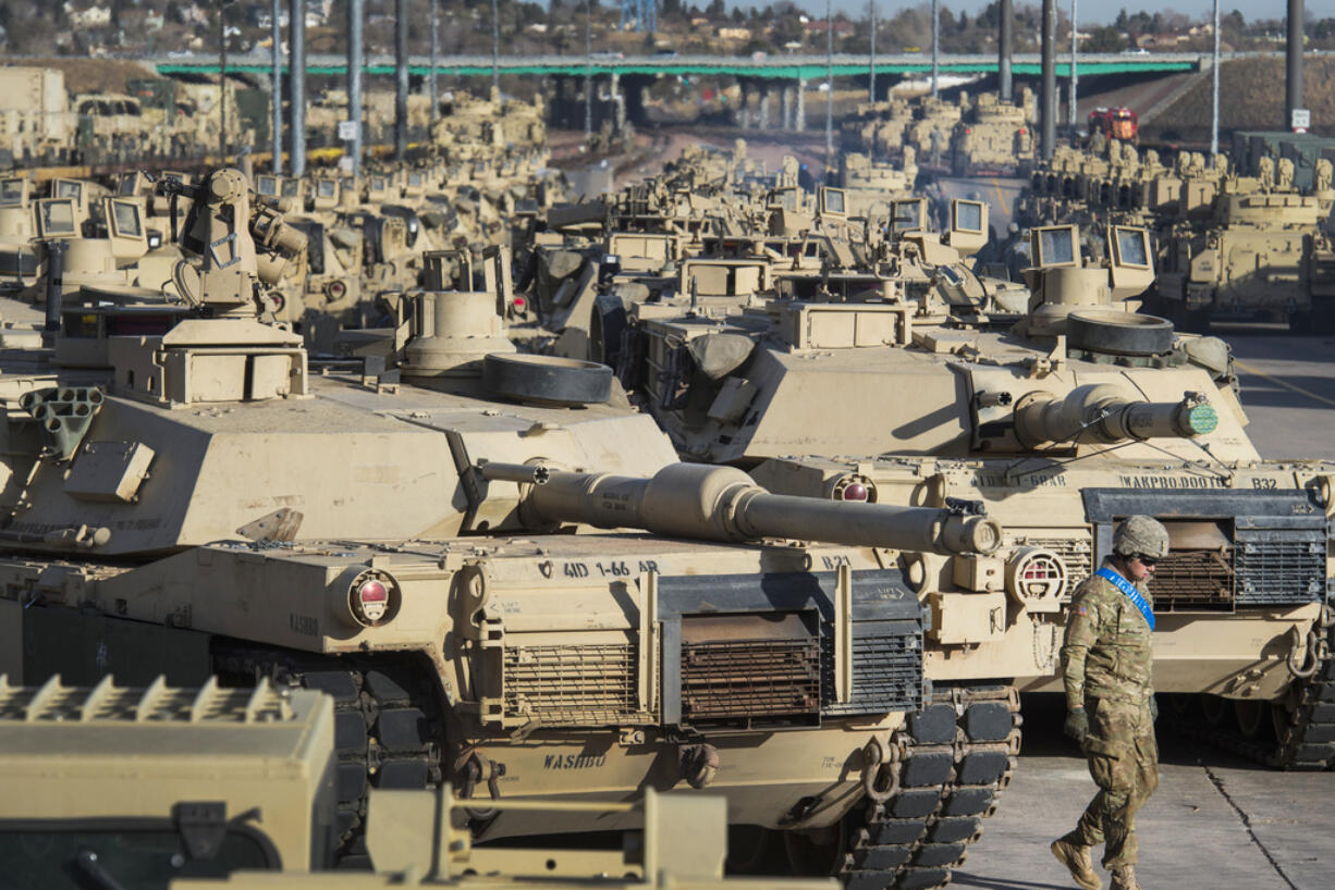 FILE - A soldier walks past a line of M1 Abrams tanks, Nov. 29, 2016, at Fort Carson in Colorado Springs, Colo.  U.S. officials say the Pentagon is speeding up its delivery of Abrams tanks to Ukraine, opting to send a refurbished older model that can be ready faster. The aim is to get the 70-ton battle powerhouses to the war zone in eight to 10 months.