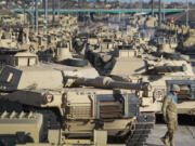 FILE - A soldier walks past a line of M1 Abrams tanks, Nov. 29, 2016, at Fort Carson in Colorado Springs, Colo.  U.S. officials say the Pentagon is speeding up its delivery of Abrams tanks to Ukraine, opting to send a refurbished older model that can be ready faster. The aim is to get the 70-ton battle powerhouses to the war zone in eight to 10 months.
