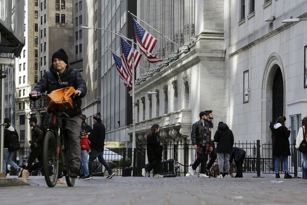 People pass the front of the New York Stock Exchange in New York, Tuesday, March 21, 2023. Stocks are rising on Wall Street, including the banks most beaten down by the industry's crisis.