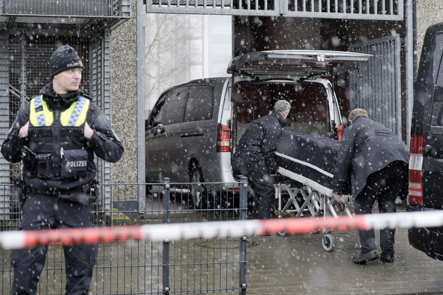 Corpses are carried out of a Jehovah's Witness building and loaded into hearses in Hamburg, Germany Friday, March 10, 2023. Shots were fired inside the building used by Jehovah's Witnesses in the northern German city of Hamburg on Thursday evening, with multiple people killed and wounded, police said.