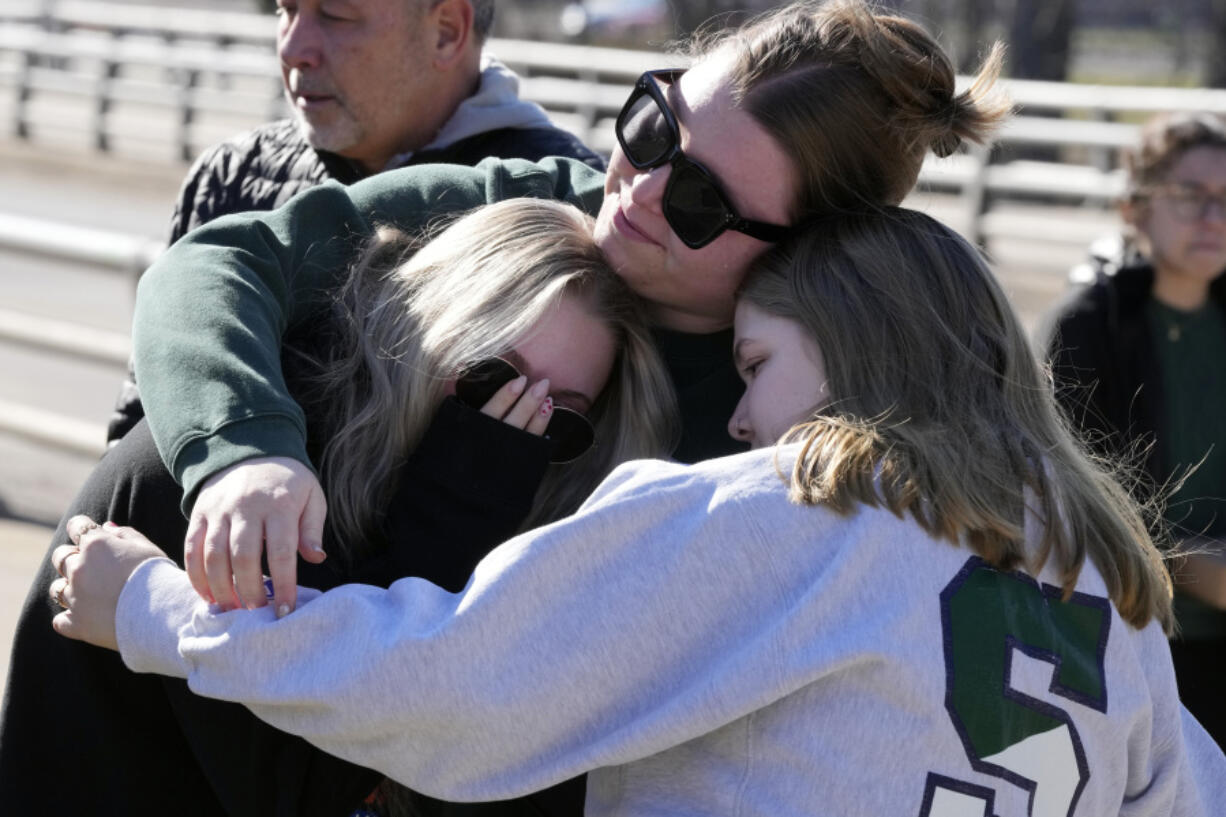 Michigan State University students embrace at The Rock on campus, Tuesday, Feb. 14, 2023, in East Lansing, Mich.  Police say the gunman who killed himself hours after fatally shooting three students at Michigan State University was 43-year-old Anthony McRae. Police also say five people who are in critical condition Tuesday are also students.