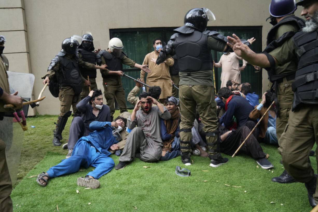 Police detain supporters of former Prime Minister Imran Khan during a search operation in Khan's residence Saturday in Lahore, Pakistan. (K.M.