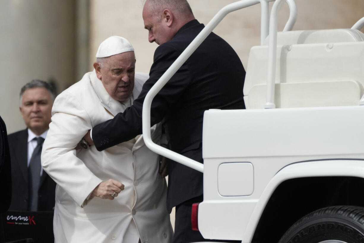 Pope Francis is helped into his car at the end of the weekly general audience in St. Peter's Square, at the Vatican, Wednesday, March 29, 2023. Pope Francis went to a Rome hospital on Wednesday for some previously scheduled tests, slipping out of the Vatican after his general audience and before the busy start of Holy Week this Sunday.