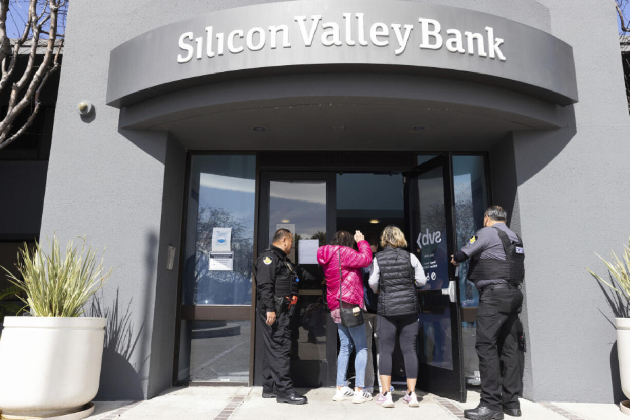 Security guards let individuals enter the Silicon Valley Bank's headquarters in Santa Clara, Calif., on Monday, March 13, 2023. The federal government intervened Sunday to secure funds for depositors to withdraw from Silicon Valley Bank after the banks collapse. Dozens of individuals waited in line outside the bank to withdraw funds.
