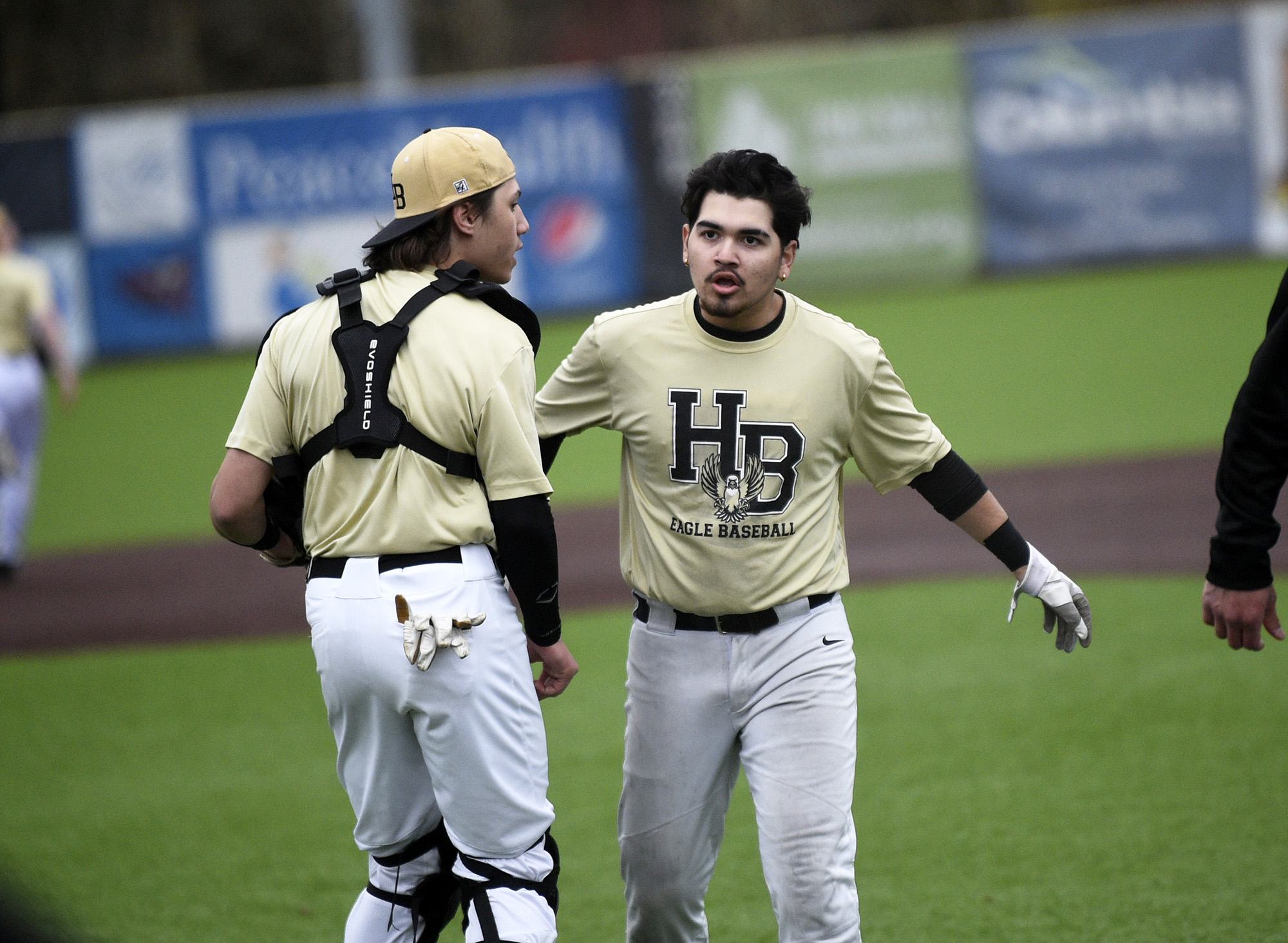 Elias Estrada (right) is congratulated by teammate Jason Soumokil after Estrada singled home the go-ahead run in the seventh inning of Bay’s 3-2 win over Ridgefield on Monday, March 27, 2023.