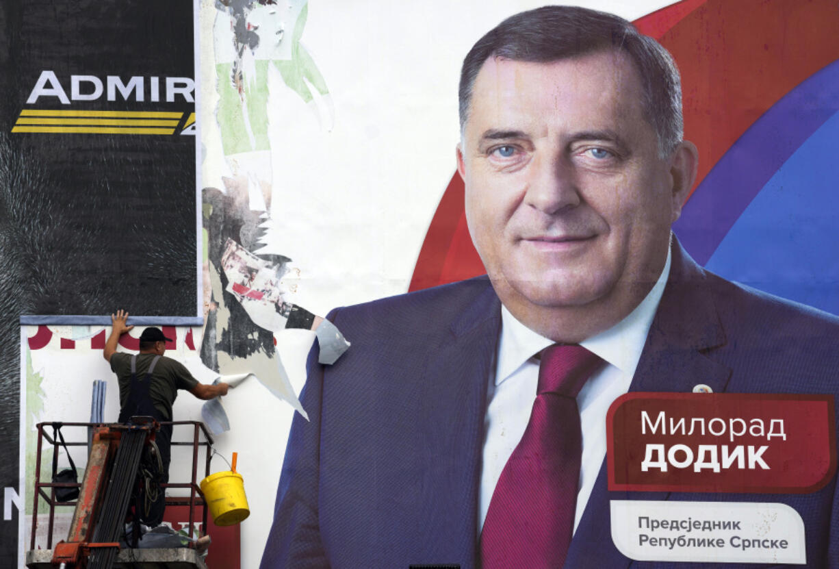 FILE - A worker removes a pre-election billboard showing Bosnian Serb leader Milorad Dodik, who chose to run for the president of Bosnia's Serb-run part, a day after a general elections in the Bosnian town of Banja Luka, 240 kms northwest of Sarajevo, on Oct. 3, 2022. U.S. Secretary of State Antony Blinken has compared the policies of separatist leader of the Serbs in Bosnia to those of Russian President Vladimir Putin following his moves to curb dissent and LGBTQ rights.