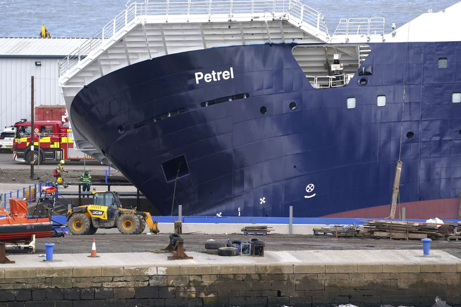 Emergency services work at Imperial Dock, where a ship has become dislodged from its holding and is partially toppled over, in Leith, Edinburgh, Scotland, Wednesday March 22, 2023.