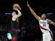 Chicago Bulls guard Zach LaVine, left, shoots over Portland Trail Blazers forward Jabari Walker during the second half of an NBA basketball game in Portland, Ore., Friday, March 24, 2023.