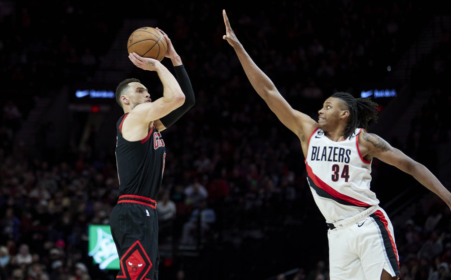 Chicago Bulls guard Zach LaVine, left, shoots over Portland Trail Blazers forward Jabari Walker during the second half of an NBA basketball game in Portland, Ore., Friday, March 24, 2023.