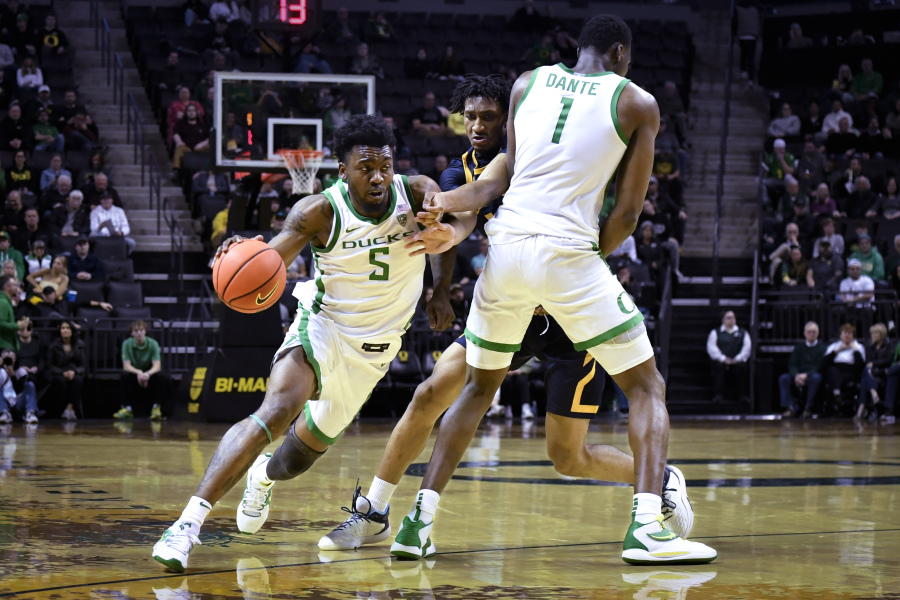 Oregon guard Jermaine Couisnard (5) moves around a screen by center N'Faly Dante (1) on California forward Grant Newell (14) during the first half of an NCAA college basketball game Thursday, March 2, 2023, in Eugene, Ore.