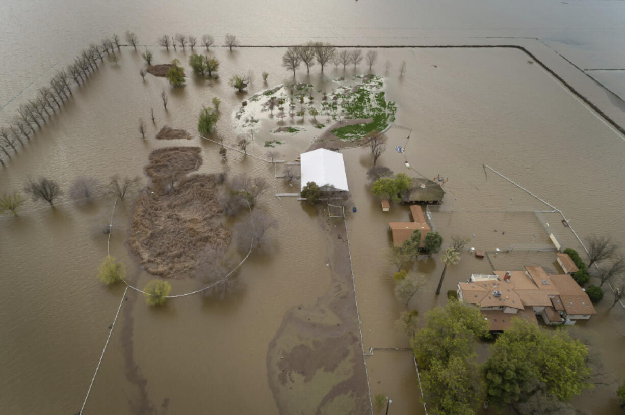 An expansive home along 6th Avenue sits in rising floodwaters after levee breaks caused extensive flooding around Corcoran, Calif., on Tuesday, March 21, 2023. Flooding in the lower Central Valley of California has brought back a long-unseen seasonal body of water, Tulare Lake.