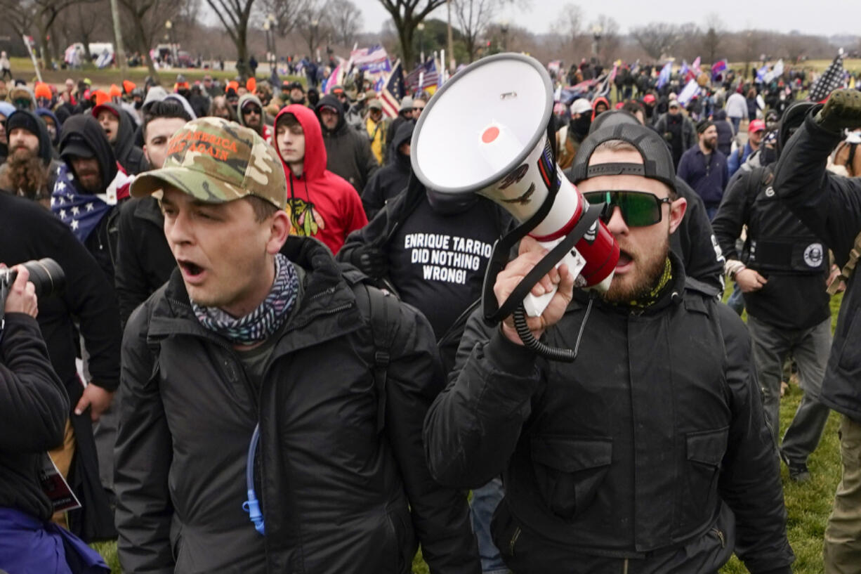 FILE - Proud Boys members Zachary Rehl, left, and Ethan Nordean, walk toward the U.S. Capitol in Washington, in support of President Donald Trump, Jan. 6, 2021. Federal prosecutors disclosed Wednesday, March 22, 2023, that a witness expected to testify for the defense at the seditious conspiracy trial of former Proud Boys leader Enrique Tarrio and four associates was secretly acting as a government informant for nearly two years after the Jan. 6 attack on the U.S. Capitol, a defense lawyer said in a court filing.