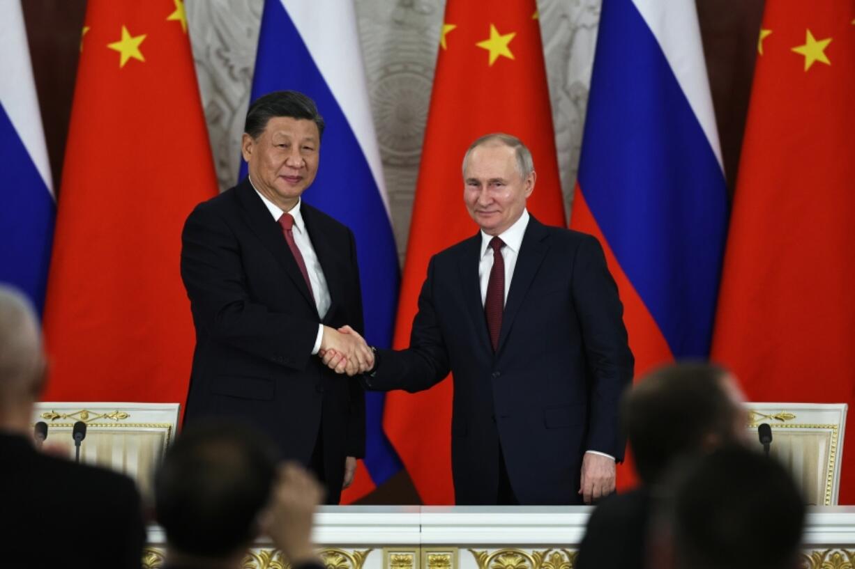 FILE - Russian President Vladimir Putin, right, and Chinese President Xi Jinping shake hands after speaking to the media during a signing ceremony following their talks at The Grand Kremlin Palace, in Moscow, Russia, March 21, 2023. China's leader Xi just concluded his three-day visit with Russian President Vladimir Putin, a warm affair in which the two men praised each other and spoke of a profound friendship.