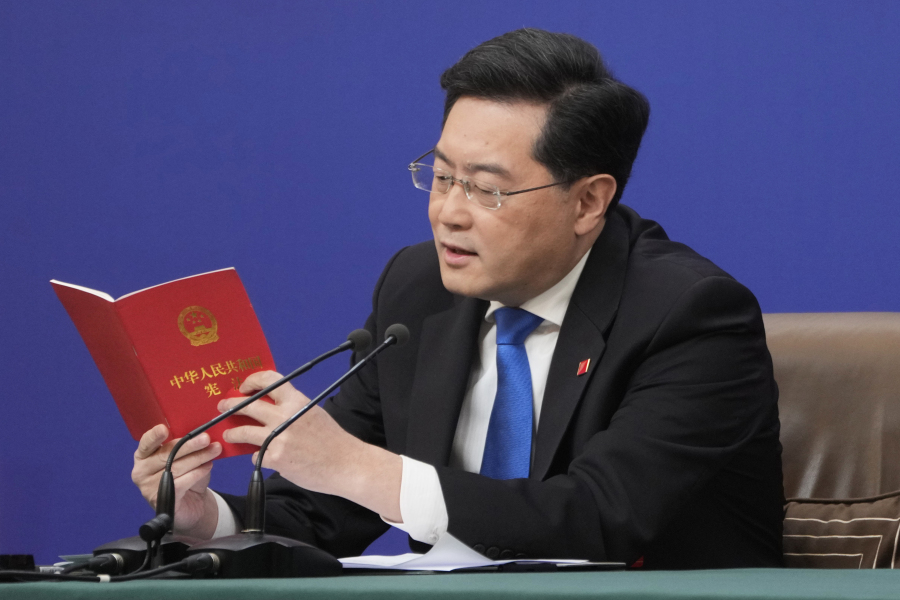 FILE - Chinese Foreign Minister Qin Gang reads from the Chinese constitution when answering a question about Taiwan during a news conference held on the sidelines of the annual meeting of China's National People's Congress (NPC) in Beijing, Tuesday, March 7, 2023. China's President Xi Jinping accused Washington Monday of trying to isolate his country and hold back its development. Xi also said a U.S.-led campaign of "containment and suppression" of China has "brought unprecedented, severe challenges." He called on the public to "dare to fight." Qin on Tuesday sharpened the warning, saying Washington faces possible "conflict and confrontation" if it fails to change course.