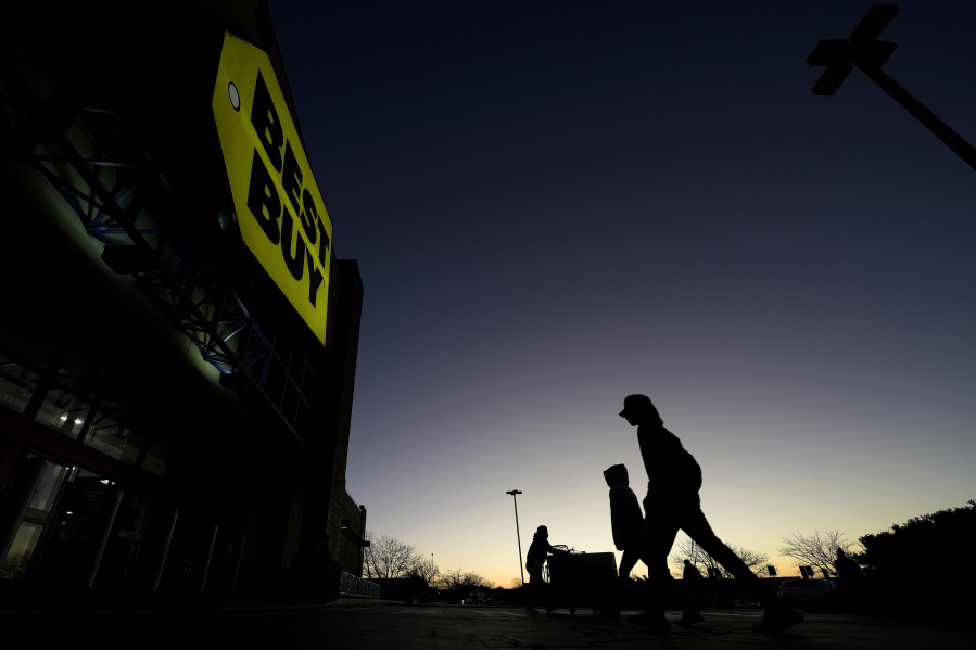 FILE - Shoppers are silhouetted against the sky as they arrives for a sale at a Best Buy store Friday, Nov. 25, 2022, in Overland Park, Kan. On Friday, the Commerce Department issues its February report on consumer spending.