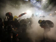 FILE - Federal officers launch tear gas at a group of demonstrators during a Black Lives Matter protest at the Mark O. Hatfield United States Courthouse in Portland, Ore., on July 26, 2020. More than 119,000 people have been injured by tear gas and other chemical irritants around the world since 2015 and some 2,000 suffered injuries from "less lethal" impact projectiles, according to a new report released Wednesday, March 22, 2023.