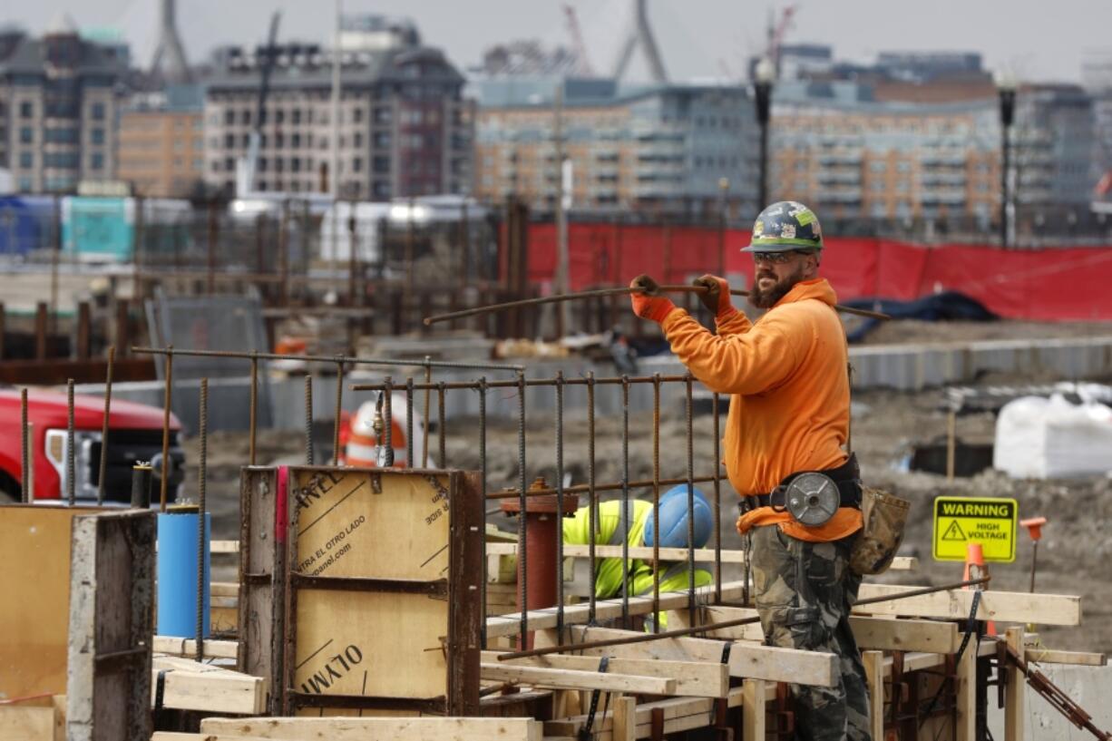 A construction worker prepares a recently poured concrete foundation, Friday, March 17, 2023, in Boston. On Thursday, the Commerce Department issues its third and final estimate of how the U.S.