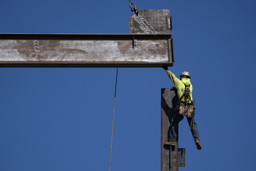 An ironworker guides a beam during construction of a municipal building in Norristown, Pa., Wednesday, Feb. 15, 2023. The strength of the American job market has consistently defied expectations throughout the economic tumult of the COVID years.
