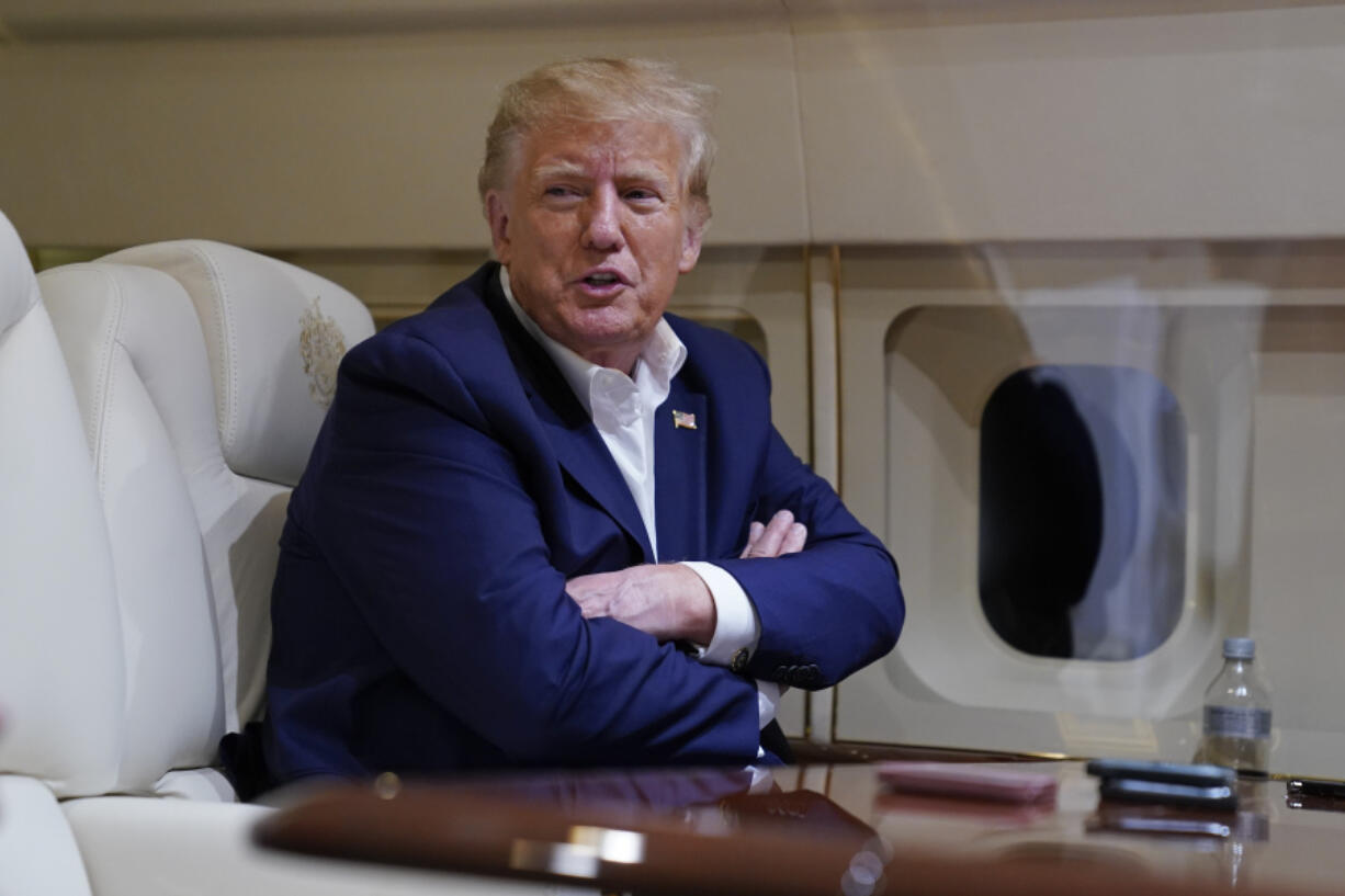 Former President Donald Trump speaks with reporters while in flight on his plane after a campaign rally at Waco Regional Airport, in Waco, Texas, Saturday, March 25, 2023, while en route to West Palm Beach, Fla.