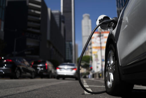 FILE - An electric vehicle is plugged into a charger in Los Angeles, Thursday, Aug. 25, 2022. Fewer new electric vehicles will qualify for a full $7,500 federal tax credit later this year, and many will get only half that under rules proposed Friday, March 30, 2023, by the U.S. Treasury Department. The rules are required under last year's Inflation Reduction Act. (AP Photo/Jae C.