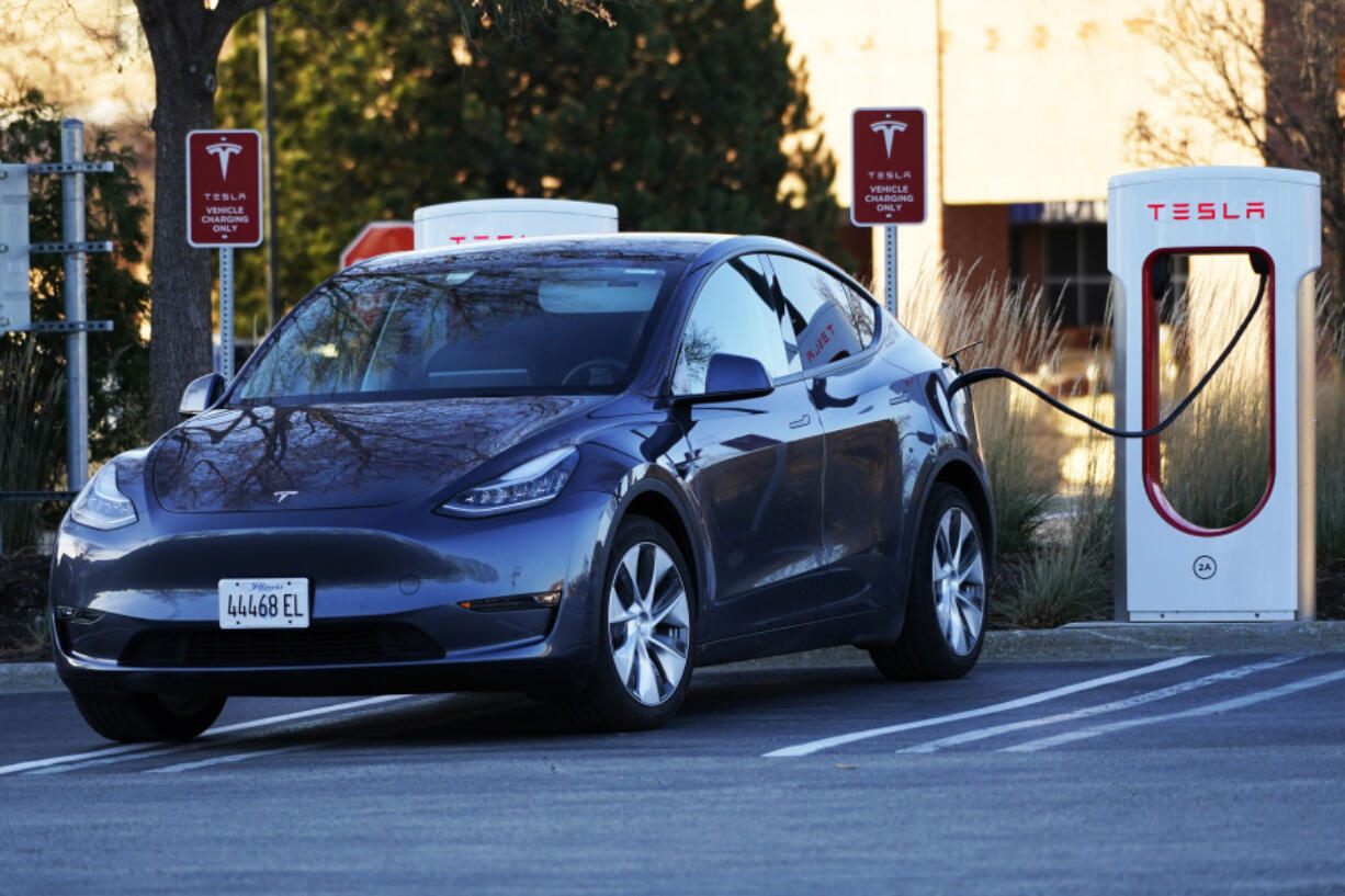 A Tesla electric vehicle is seen at a Tesla electric vehicle charging station at Willow Festival shopping plaza parking lot in Northbrook, Ill., Saturday, Dec. 3, 2022. (AP Photo/Nam Y.