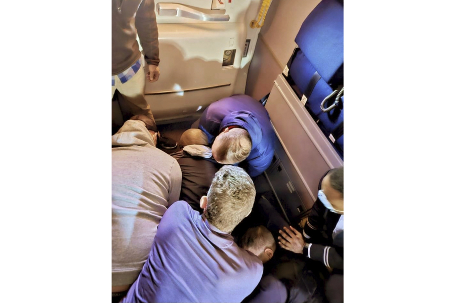 FILE -- This image provided by Simik Ghookasian shows passengers and crew members restraining a man who according to federal authorities tried to stab a flight attendant on a flight from Los Angeles to Boston on March 5, 2023. Francisco Torres, the Massachusetts man accused of attacking the flight attendant and attempting to open the plane's emergency door on a cross-country flight, has directed attention to passengers with mental health challenges.