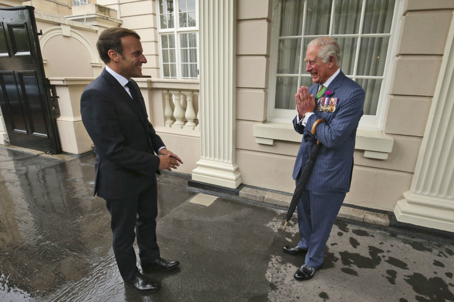 FILE - Britain's Prince Charles welcomes French president Emmanuel Macron, left, to Clarence House in London, Thursday June 18, 2020. French President Emmanuel Macron's office on Friday, March 24, 2023, said a state visit by Britain's King Charles III has been postponed amid mass strikes and protests in France. The king had been scheduled to arrive in France on Sunday on his first state visit as monarch, before heading to Germany on Wednesday.
