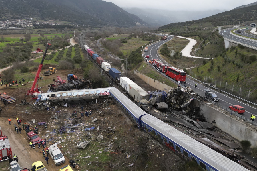 A crane, firefighters and rescuers operate after a collision in Tempe near Larissa city, Greece, Wednesday, March 1, 2023. A train carrying hundreds of passengers has collided with an oncoming freight train in northern Greece, killing and injuring dozens passengers.
