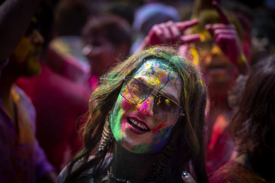 A girl smeared with colors celebrates Holi, the festival of colors on a street in Guwahati, India, Wednesday, March 8, 2023.Millions of Indians on Wednesday celebrated the ''Holi" festival, dancing to the beat of drums and smearing each other with green, yellow and red colors and exchanging sweets in homes, parks and streets. Free from mask and other COVID-19 restrictions after two years, they also drenched each other with colored water.