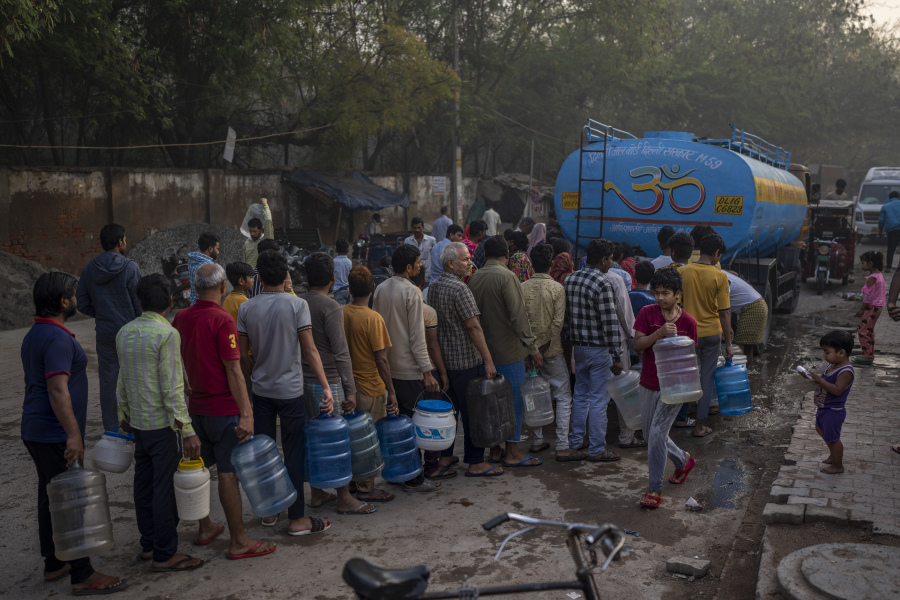 People wait for their turn to collect drinking water from a mobile water tanker on World Water Day in a residential area in New Delhi, India, Wednesday, March 22, 2023. From droughts stifling once-reliant sources to destructive downpours and floods, what the world does about its water woes is the central question at the U.N.'s three-day water conference that begins Wednesday which also marks the 30th anniversary of World Water Day.