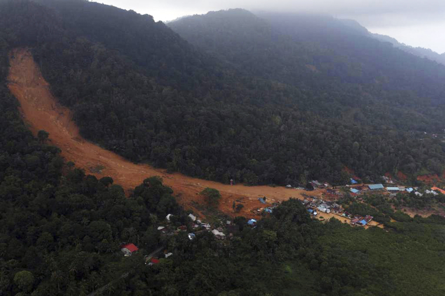 This aerial photo released by Indonesia's National Disaster Management Agency (BNPB) on Wednesday, March 8, 2023, shows a village affected by landslide on Serasan Island, Natuna regency, Indonesia. Rescuers in the remote Indonesian islands are searching for people who are believed to be buried in their houses by landslides that tore through villages after torrential rains and killed a number of people.