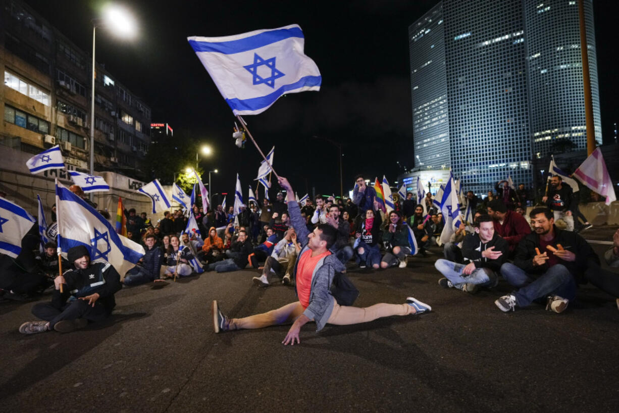 Demonstrators block a highway during protest against plans by Prime Minister Benjamin Netanyahu's government to overhaul the Israel's judicial system, in Tel Aviv, Israel, Saturday, March 18, 2023.