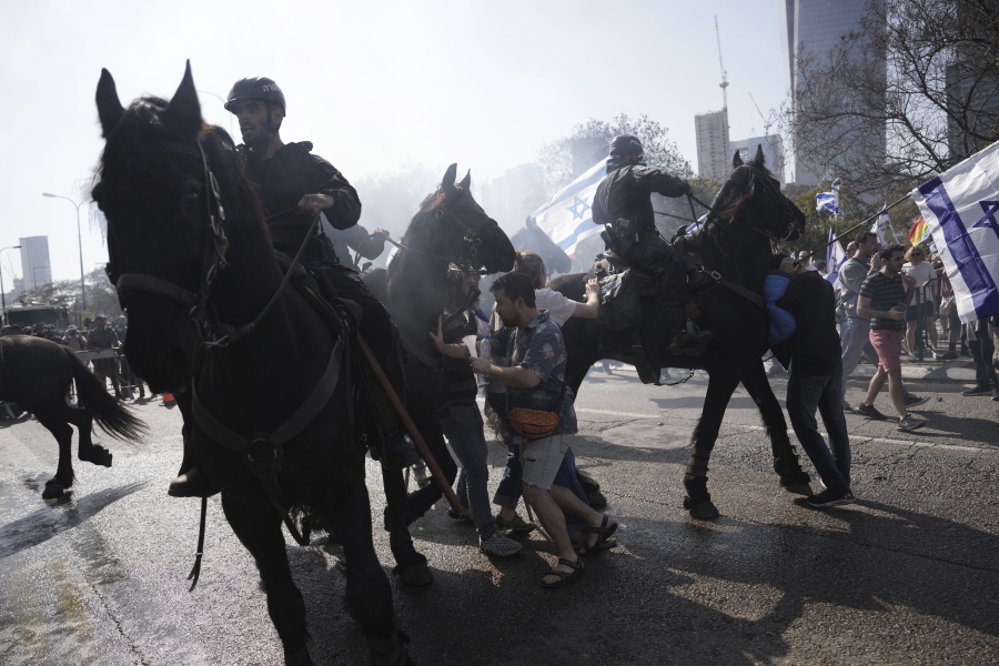 Israeli police deploy horses and stun grenades to disperse Israelis blocking a main road to protest against plans by Prime Minister Benjamin Netanyahu's new government to overhaul the judicial system, in Tel Aviv, Israel, Wednesday, March 1, 2023.
