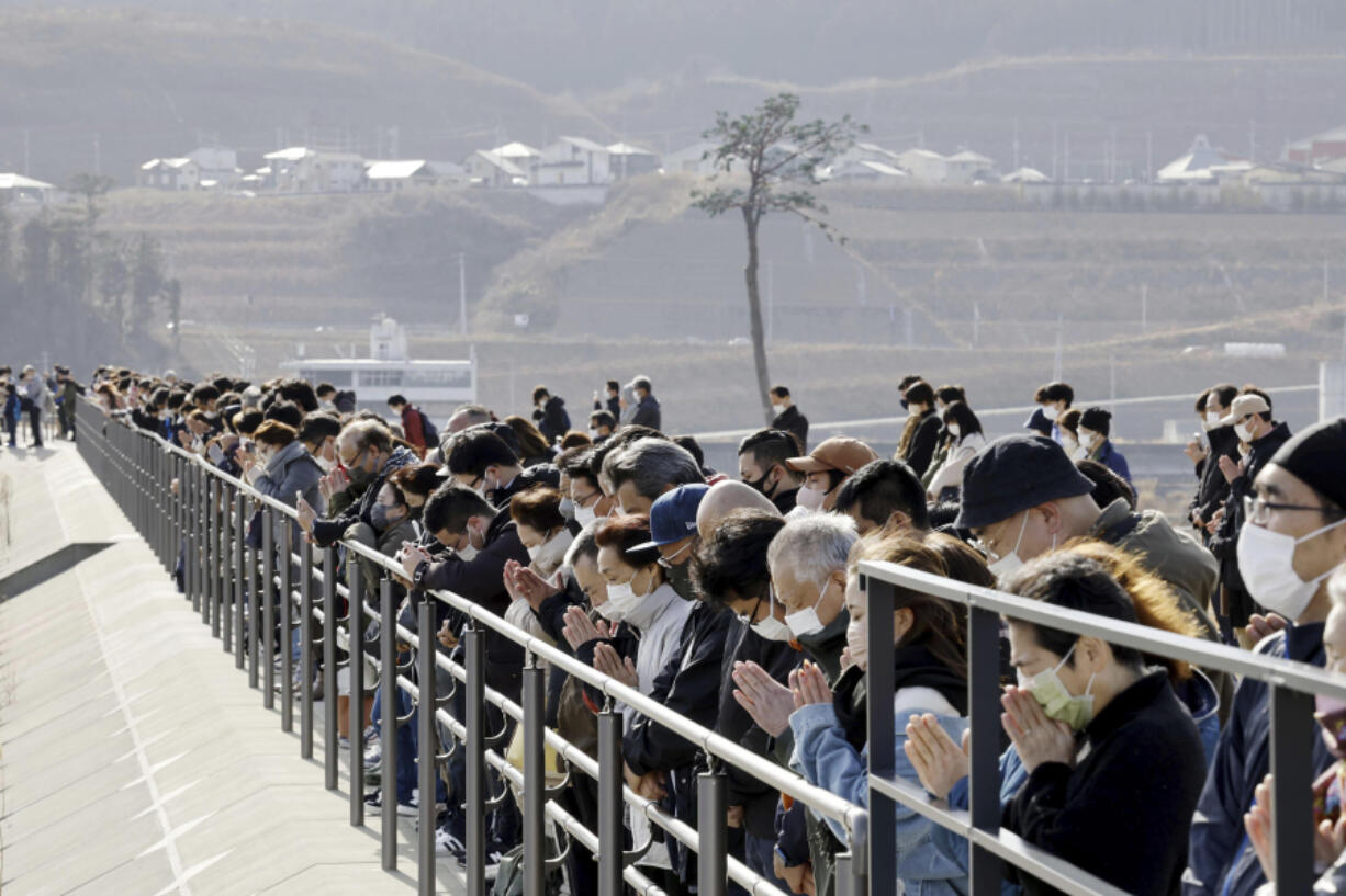People observe a moment of silence at 2:46 p.m., the moment the earthquake struck in Rikuzentakata, Iwate prefecture on Saturday, March 11, 2023. Japan on Saturday marked the 12th anniversary of the massive earthquake, tsunami and nuclear disaster with a minute of silence, as concerns grew ahead of the planned release of the treated radioactive water from the wrecked Fukushima nuclear plant and the government's return to nuclear energy.