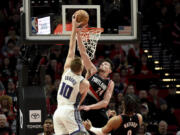 Sacramento Kings forward Domantas Sabonis dunks against Portland Trail Blazers forward Drew Eubanks, right, during the second half of an NBA basketball game in Portland, Ore., Friday, March 31, 2023. The Kings won 138-114.