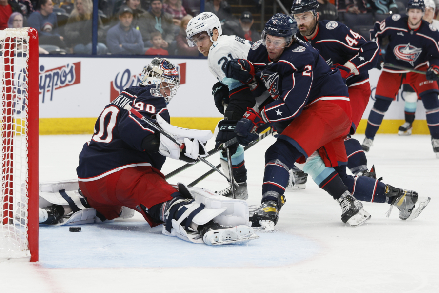 Seattle Kraken's Alex Wennberg (21) scores against Columbus Blue Jackets' Elvis Merzlikins, left, as Andrew Peeke, right front, defends during the third period of an NHL hockey game Friday, March 3, 2023, in Columbus, Ohio.
