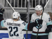 Seattle Kraken right wing Oliver Bjorkstrand (22) celebrates with defenseman Vince Dunn (29), who scored an overtime goal against the San Jose Sharks in an NHL hockey game in San Jose, Calif., Thursday, March 16, 2023.