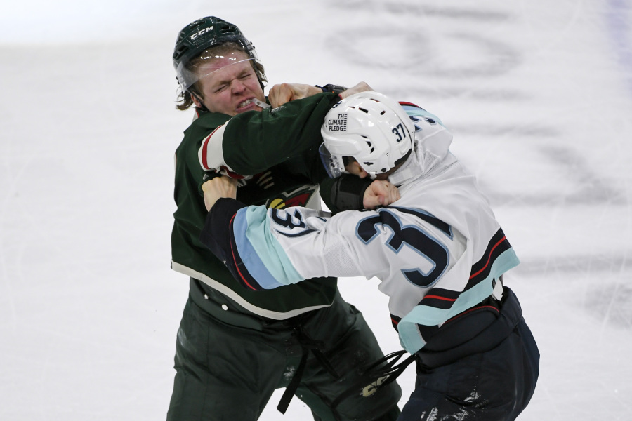 Minnesota Wild center Mason Shaw, left, and Seattle Kraken left wing Yanni Gourde fight during the third period of an NHL hockey game Monday, March 27, 2023, in St. Paul, Minn. Both drew major penalties for fighting.